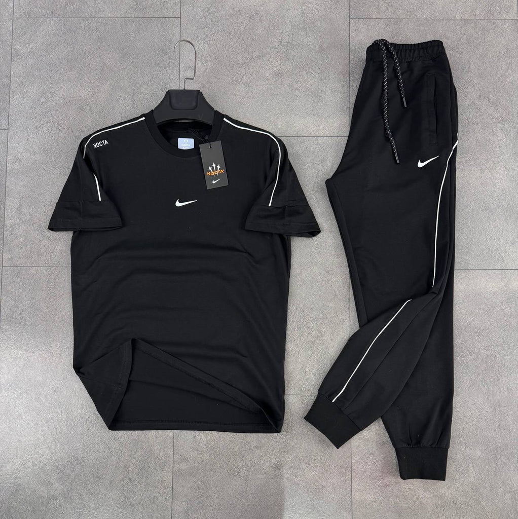 Moški komplet Nike 'Nocta', majica in dolge hlače v črni barvi, z belim trakom in emblemom na rami.